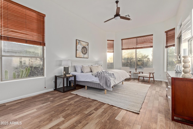 bedroom with multiple windows, ceiling fan, and light hardwood / wood-style floors