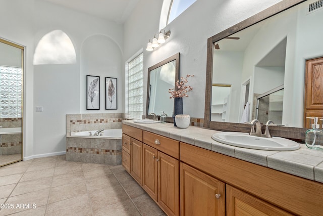 bathroom with tile patterned floors, independent shower and bath, and vanity