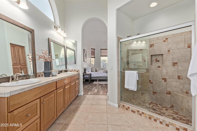 bathroom with an enclosed shower, tile patterned flooring, and vanity