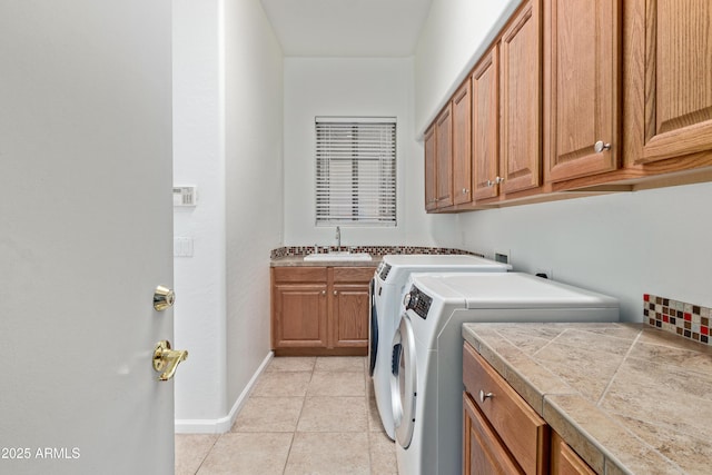 laundry room with sink, cabinets, light tile patterned flooring, and washing machine and clothes dryer