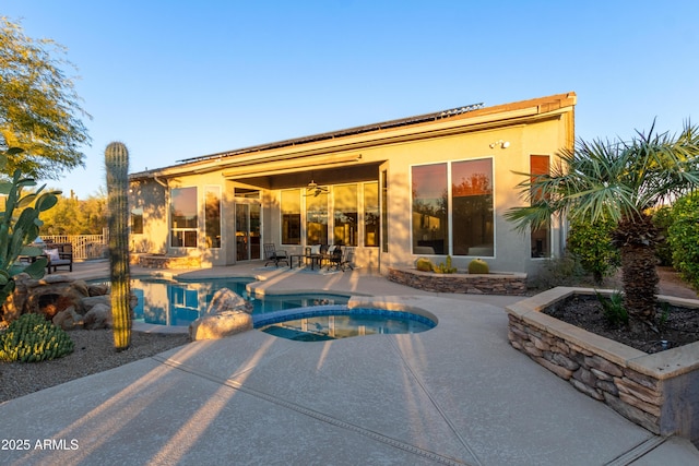 view of swimming pool with ceiling fan, a patio, and an in ground hot tub