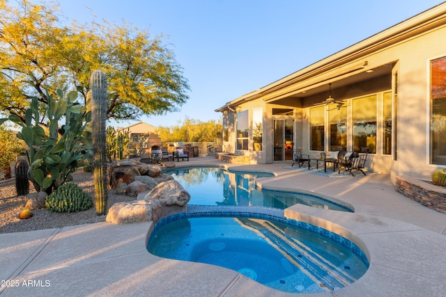 view of pool featuring a patio area, ceiling fan, and an in ground hot tub