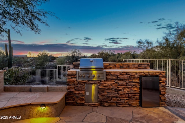 patio terrace at dusk featuring area for grilling