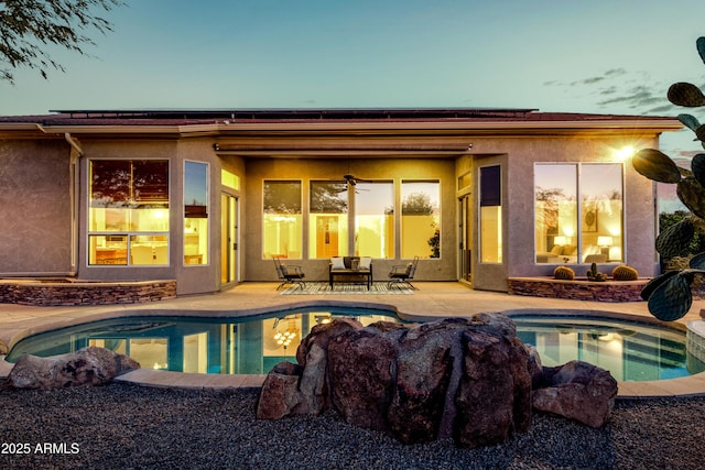 pool at dusk featuring a patio