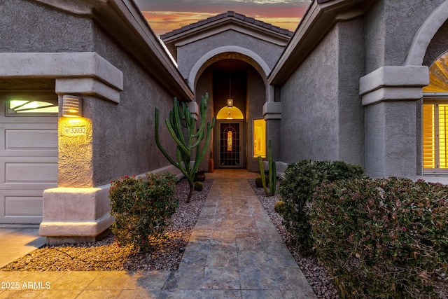 exterior entry at dusk with a garage