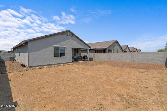 back of property featuring a fenced backyard and stucco siding