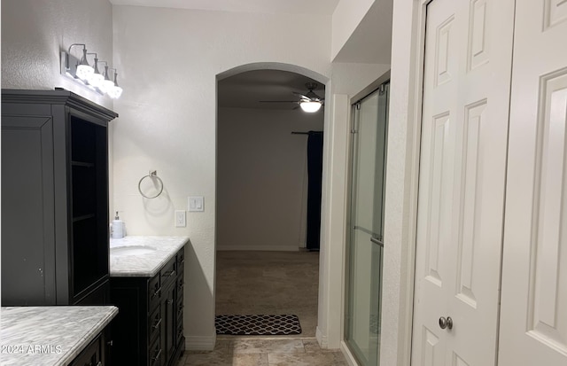 bathroom featuring ceiling fan, vanity, and an enclosed shower