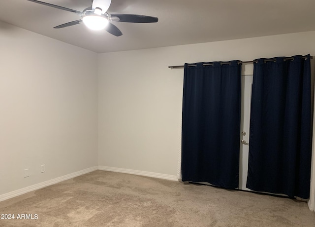 carpeted spare room with ceiling fan