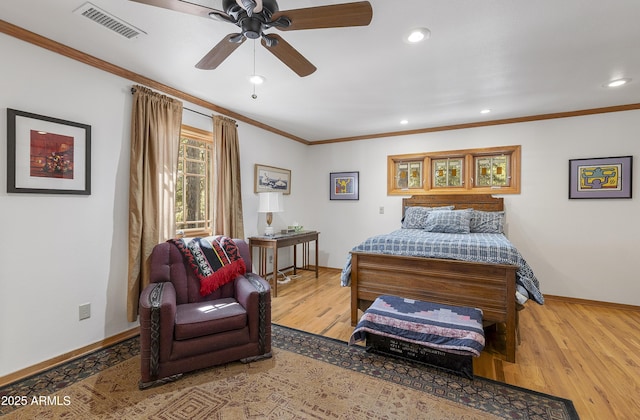 bedroom featuring baseboards, visible vents, wood finished floors, and ornamental molding