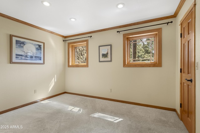 empty room with carpet flooring, crown molding, and baseboards