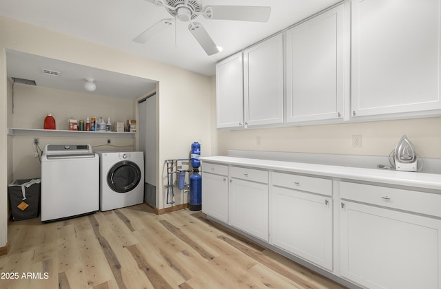 laundry room with ceiling fan, visible vents, light wood-style floors, cabinet space, and washing machine and clothes dryer