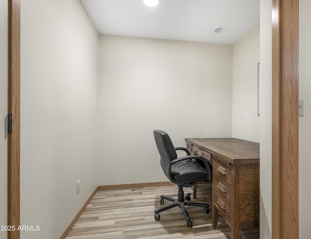 home office with light wood-style flooring and baseboards