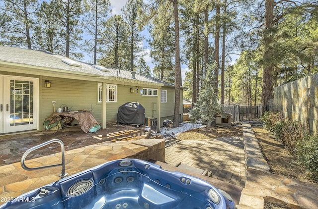 exterior space with a patio, a hot tub, and fence