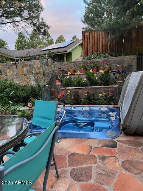 patio terrace at dusk featuring outdoor dining space and fence