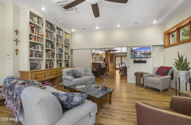 living area with a ceiling fan, a healthy amount of sunlight, visible vents, and wood finished floors