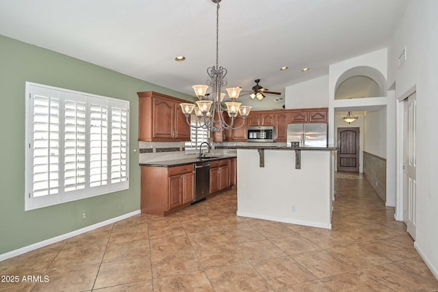 5226 W Pontiac Dr, Glendale, AZ 85308 - kitchen with a breakfast bar, brown cabinets, appliances with stainless steel finishes, pendant lighting, and a sink