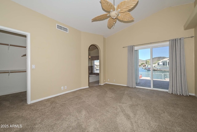 5226 W Pontiac Dr, Glendale, AZ 85308 - unfurnished bedroom featuring arched walkways, a walk in closet, vaulted ceiling, access to outside, and carpet flooring