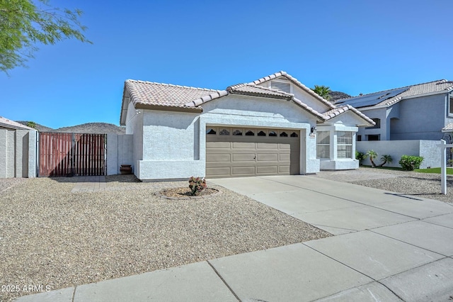 5226 W Pontiac Dr, Glendale, AZ 85308 - view of front of property with a tiled roof, a garage, concrete driveway, stucco siding, and a gate