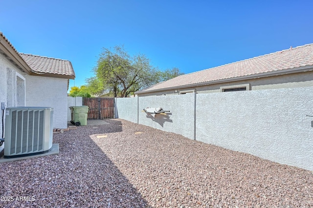 5226 W Pontiac Dr, Glendale, AZ 85308 - view of yard featuring central AC unit, a fenced backyard, and a gate