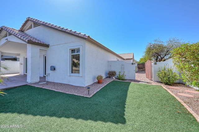 5226 W Pontiac Dr, Glendale, AZ 85308 - back of house featuring stucco siding, a patio area, a tiled roof, fence, and a lawn