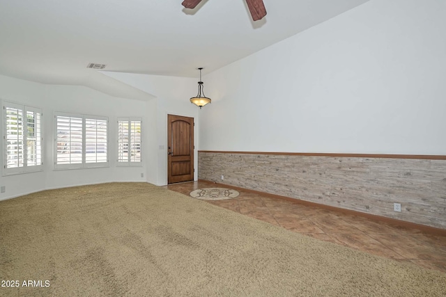 5226 W Pontiac Dr, Glendale, AZ 85308 - carpeted empty room featuring lofted ceiling, tile patterned flooring, a wainscoted wall, visible vents, and ceiling fan