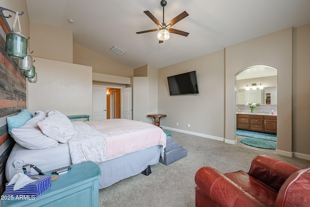 bedroom with connected bathroom, ceiling fan, light colored carpet, and vaulted ceiling