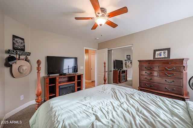 carpeted bedroom featuring ceiling fan and a closet