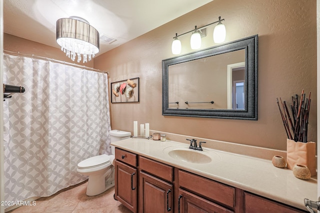 bathroom with tile patterned flooring, vanity, and toilet