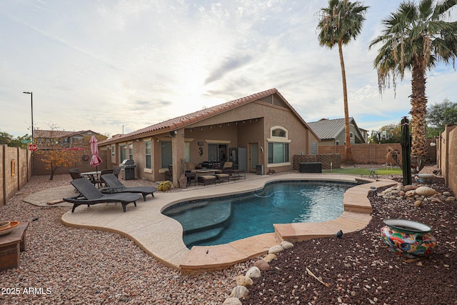 view of swimming pool featuring area for grilling and a patio area