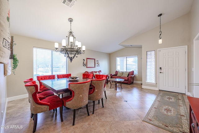 tiled dining room featuring a healthy amount of sunlight, vaulted ceiling, and a notable chandelier