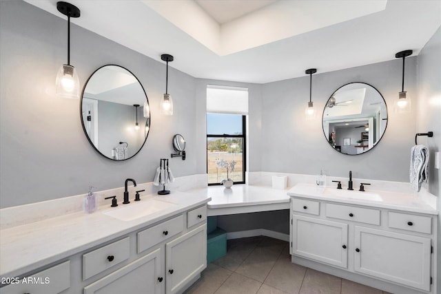 full bathroom featuring a sink, a bathing tub, two vanities, and tile patterned floors