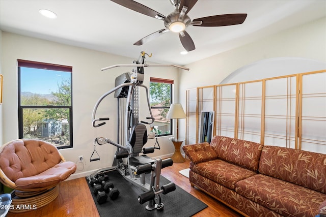 exercise area featuring recessed lighting, baseboards, wood finished floors, and a ceiling fan