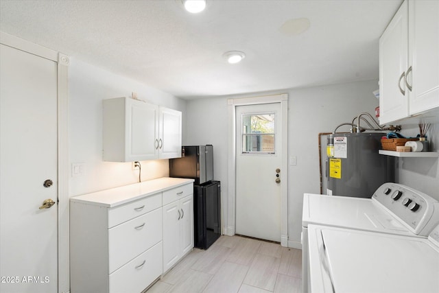 laundry area with washer and dryer, cabinet space, and electric water heater