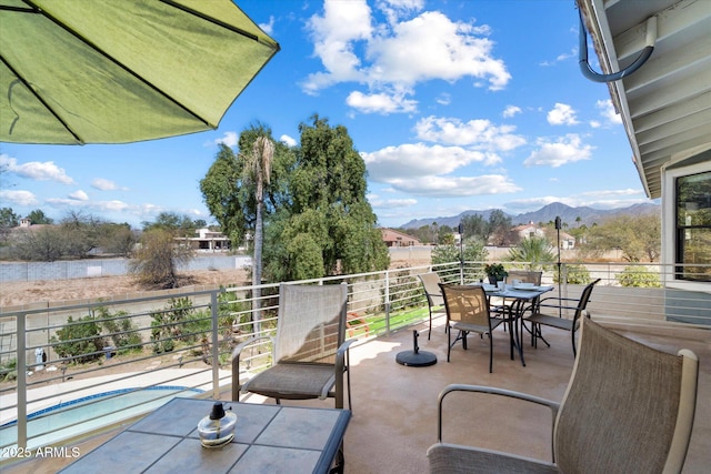 view of patio / terrace featuring outdoor dining space, a balcony, and a mountain view