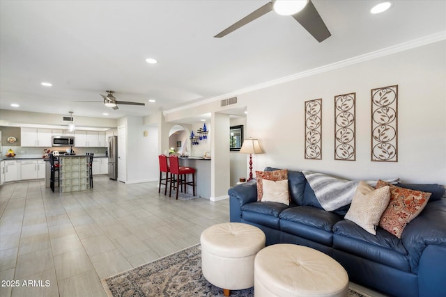 living area featuring recessed lighting, visible vents, baseboards, and crown molding