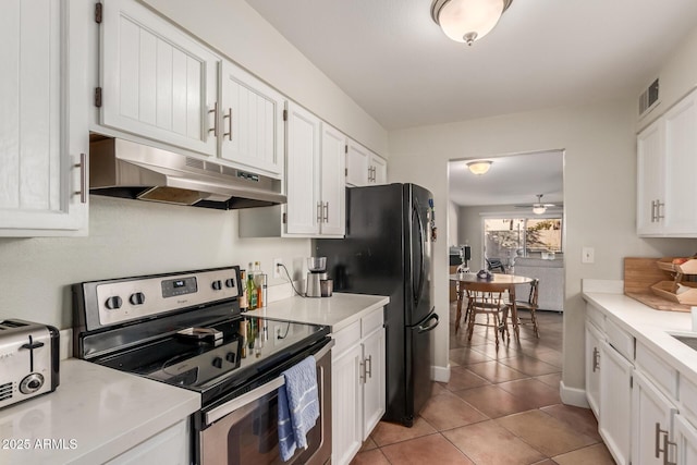 kitchen with ceiling fan, stainless steel range with electric stovetop, black refrigerator, white cabinets, and light tile patterned flooring