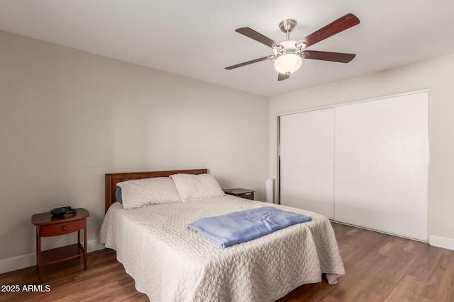 bedroom featuring ceiling fan, dark hardwood / wood-style flooring, and a closet