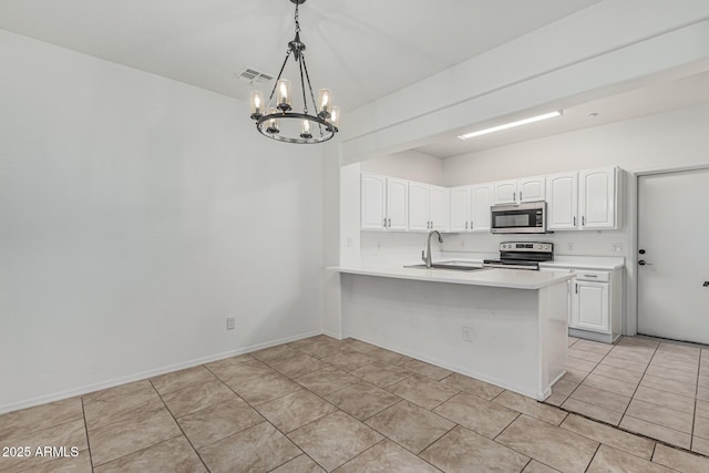 kitchen with a notable chandelier, a peninsula, white cabinets, appliances with stainless steel finishes, and a sink