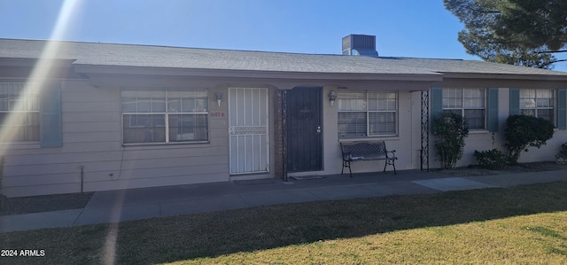 view of front facade featuring cooling unit and a front lawn