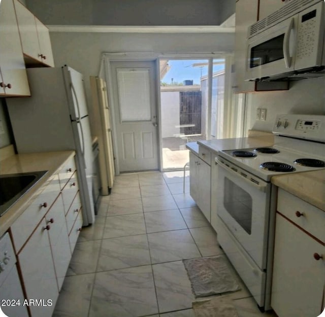 kitchen with white cabinets, white appliances, and sink