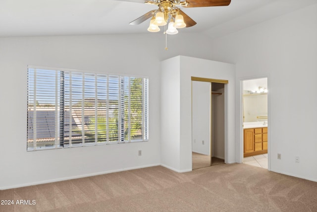 unfurnished bedroom with light colored carpet, vaulted ceiling, ceiling fan, connected bathroom, and a closet