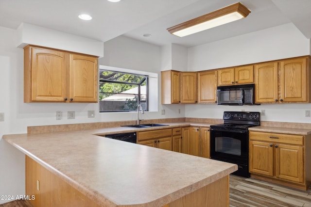 kitchen featuring kitchen peninsula, sink, black appliances, and light hardwood / wood-style flooring