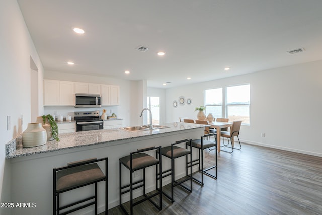 808 S Maricopa Rd, Florence, AZ 85132 - kitchen with stainless steel appliances, a sink, light stone counters, white cabinetry, and a breakfast bar area