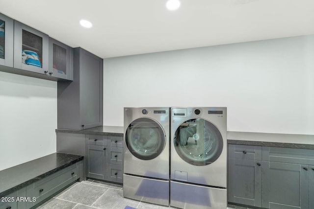 washroom with washer and clothes dryer and cabinets