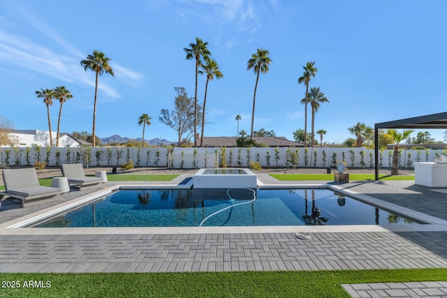 view of swimming pool featuring a mountain view, a patio, and an in ground hot tub