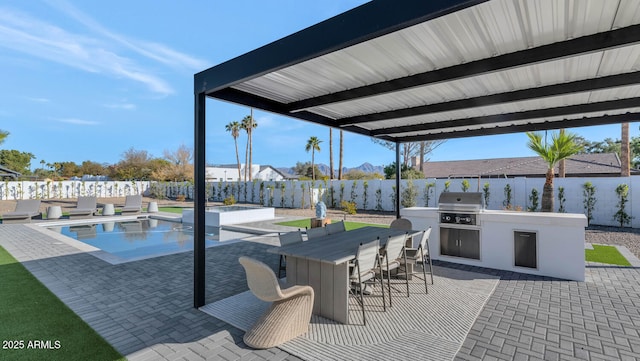 view of patio featuring exterior kitchen, a pool with hot tub, a bar, and grilling area