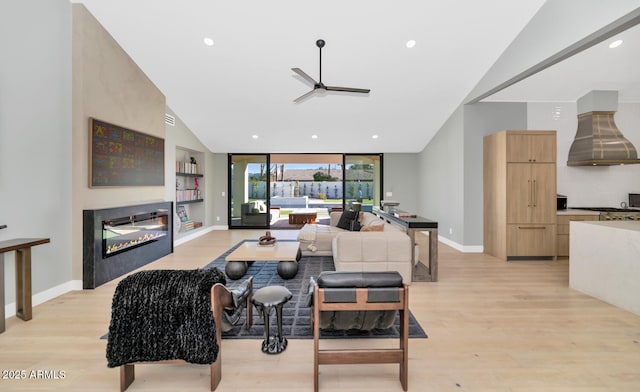 living room with ceiling fan, light wood-type flooring, and lofted ceiling