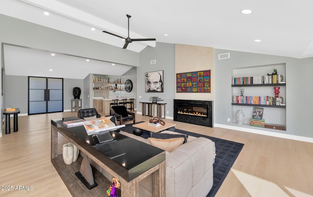 living room featuring ceiling fan, built in shelves, lofted ceiling with beams, and light hardwood / wood-style floors