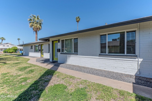 ranch-style home featuring a front lawn