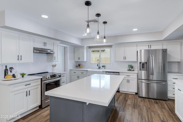 kitchen featuring stainless steel appliances, dark wood-type flooring, under cabinet range hood, and white cabinetry